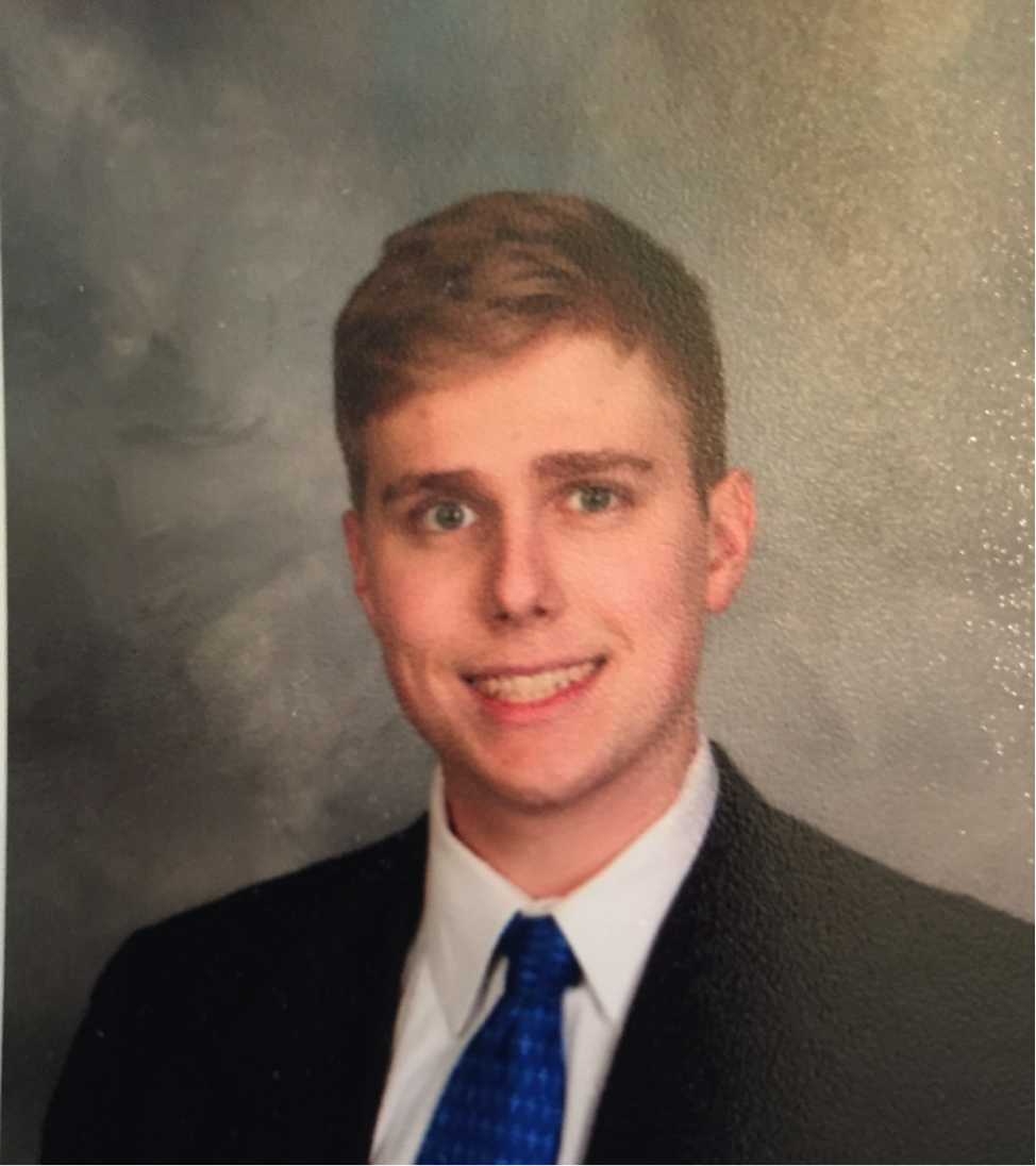 A picture of a senior photo of a smiling male student wearing a suit and tie